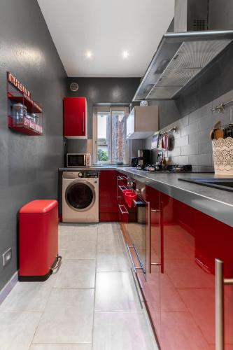 a kitchen with red cabinets and a washing machine at Maison Petillat - Calme en plein centre - 2 chambres 80m2, Wifi in Vichy