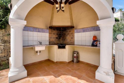 Casa Amanda في Muntanya la Sella: مطبخ خارجي مع قوس ومغسلة