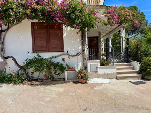 a house with flowers on the front of it at So close to the sea in Santa Maria Navarrese