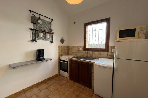 La cuisine est équipée d'un réfrigérateur et d'un évier. dans l'établissement 4-guest flat with terrace & shared pool Verdon countryside, à Artignosc-sur-Verdon