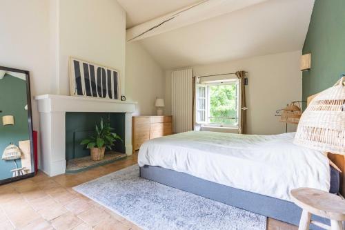 une chambre avec un lit et une cheminée dans l'établissement Mas provençal, entre vignes et oliviers, à Lambesc