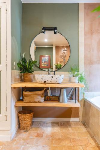 une salle de bain avec un lavabo et un miroir dans l'établissement Mas provençal, entre vignes et oliviers, à Lambesc