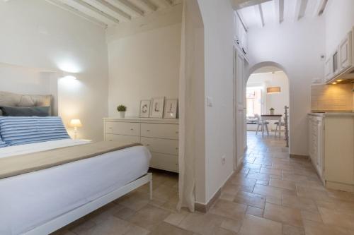 a white bedroom with a bed and a dining room at Porto Ercole Charming House - Guardabassi Collection in Porto Ercole