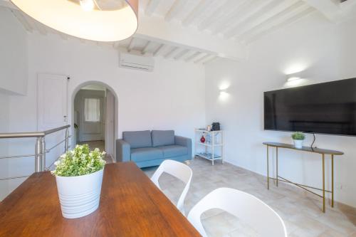 a living room with a wooden table and white chairs at Porto Ercole Charming House - Guardabassi Collection in Porto Ercole