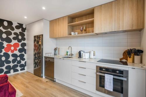 a kitchen with white appliances and wooden cabinets at Birch Street Solo Haven in Lower Hutt