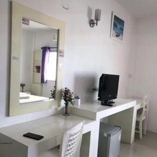 a bathroom with a vanity with a television and a mirror at NobleHouse in Ban Chek
