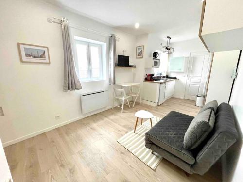 un salon avec un canapé et une cuisine dans l'établissement Charmant studio 1 neuf triangle d'or Deauville!, à Deauville