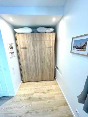 une chambre avec une porte en bois dans l'angle d'une pièce dans l'établissement Charmant studio 1 neuf triangle d'or Deauville!, à Deauville