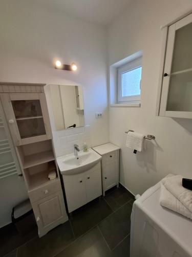 ein weißes Badezimmer mit Waschbecken und Spiegel in der Unterkunft SAB Apartament Mamaia Nord-Navodari in Mamaia Nord – Năvodari