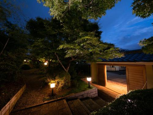 a house with two lights on a patio at night at Ryotei Jyusouya in Sango