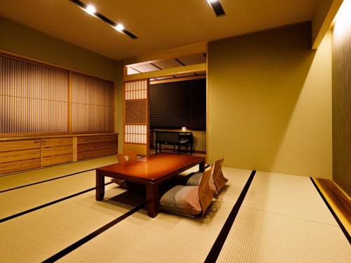 a japanese room with a table and a chair at Ryotei Jyusouya in Sango