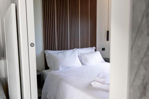 a bedroom with a white bed with white sheets and pillows at Agriturismo Il Giardino Degli Ulivi in Lazise