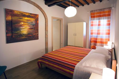 a bedroom with a bed and a painting on the wall at Agriturismo Fattoria Loppiano 4-0 in Incisa in Valdarno