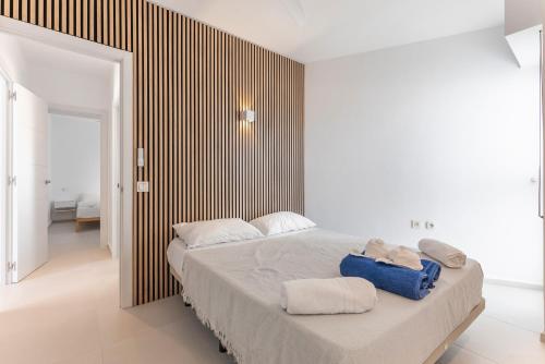 a bedroom with a large bed with towels on it at Hastinapura, acceso directo al mar in Es Castell