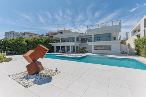 a villa with a swimming pool and a house at Hastinapura, acceso directo al mar in Es Castell