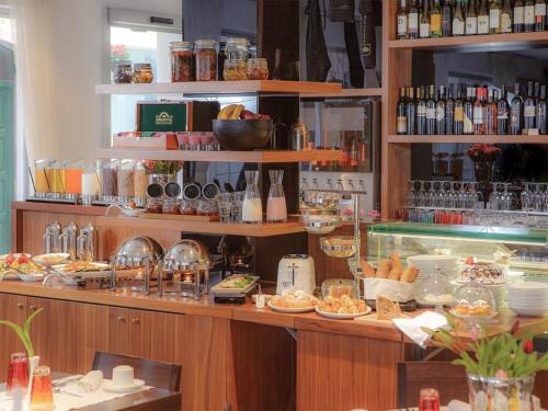 a restaurant with a counter with food on it at Marmont Heritage Hotel in Split