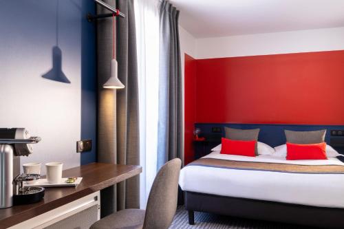 a bedroom with a bed and a red wall at Hotel Le Bugatti in Molsheim