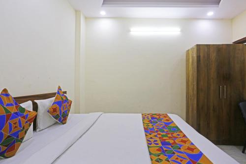 a bedroom with a bed and a wooden cabinet at Swastik residency Laxmi Nagar by Twamev in New Delhi