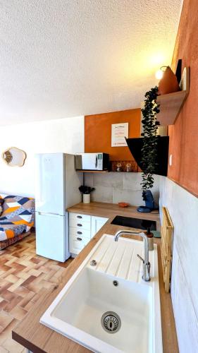- une cuisine avec un évier blanc dans l'établissement LE FIEF, Appartement à deux pas de la plage, à Port-la-Nouvelle