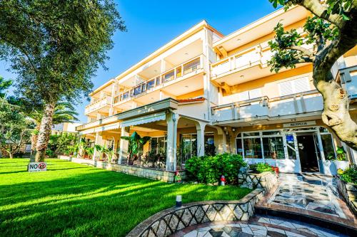 a building with a green lawn in front of it at Resort Trcol in Novalja