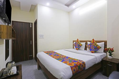 a bedroom with a large bed with colorful pillows at Swastik residency Laxmi Nagar by Twamev in New Delhi