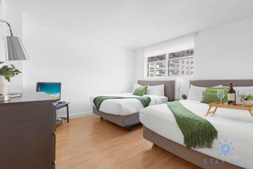 a bedroom with two beds and a television in it at Tides beautiful ocean view condo-promotions in Hollywood