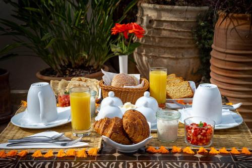 un tavolo per la colazione con vassoio di pane e succo d'arancia di Riad Vanilla Sma & Spa a Marrakech