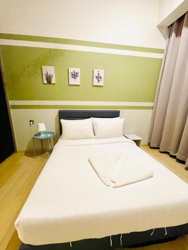 a bedroom with a large bed with white sheets at My Residence Villa Star Klcc in Kuala Lumpur