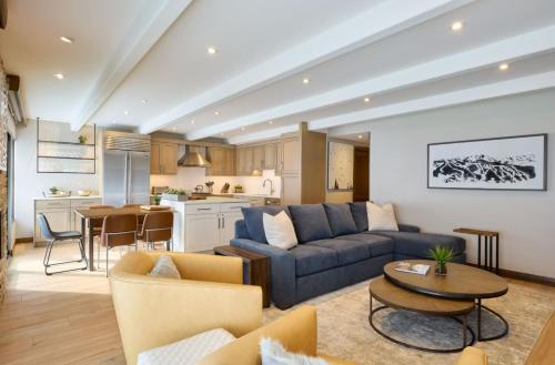 a living room with a blue couch and a kitchen at Vail - Lionshead Condominiums 2 Bedroom Condo in Vail