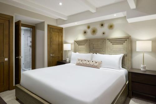 Un dormitorio con una gran cama blanca con cabecero de madera. en Vail - Lionshead Condominiums 2 Bedroom Condo, en Vail
