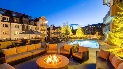 a patio with couches and a fire pit and a pool at Vail - Lionshead Condominiums 2 Bedroom Condo in Vail