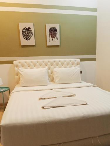 a white bed with two silver napkins on it at My Residence Villa Star Klcc in Kuala Lumpur