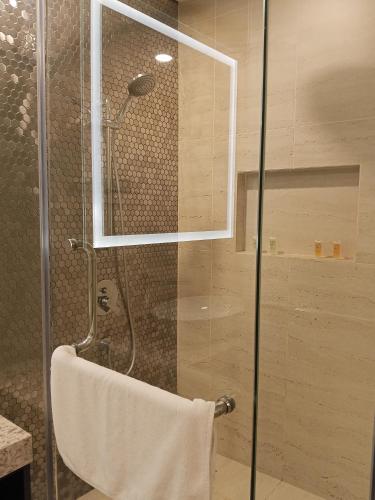 a shower with a glass door and a towel at My Residence Villa Star Klcc in Kuala Lumpur