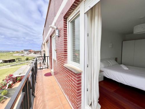 a room with a balcony with a bed and a window at Apartamento La Cala Cuchía - Monabri in Cuchia