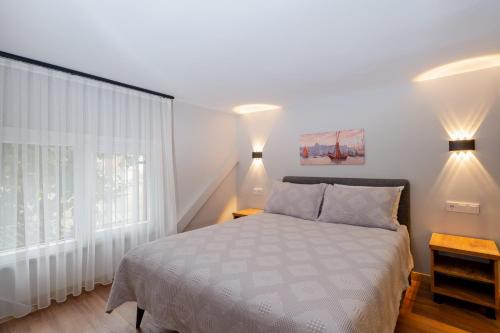 a white bedroom with a bed and a window at The Han YK Hotel in Avcılar