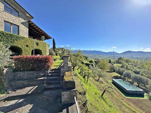 a house with a stone stairway leading up to a house at Villa Delia 16p 2 Pools BBQ by VILLASRETREATS in Talavorno