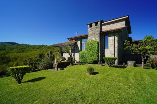 a house with a grassy yard in front of it at Villa Delia 16p 2 Pools BBQ by VILLASRETREATS in Talavorno