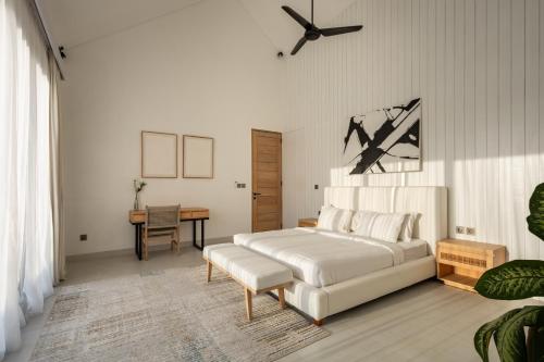 a bedroom with a white bed and a table at Spacious 3 bedroom villa - Walk to the beach in Uluwatu