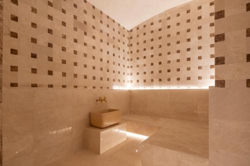 a bathroom with a toilet in a room with tiles at Eurostars Casa Anfa in Casablanca