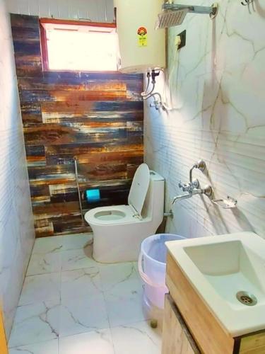 a bathroom with a toilet and a sink at Hotel Mahadev in Badrinath