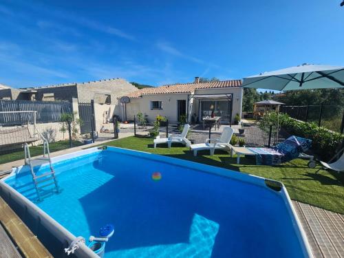 - une piscine bleue dans une cour à côté d'une maison dans l'établissement Alicante, à Causses-et-Veyran