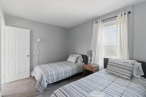 a bedroom with two beds and a window at Modern 6BR Near Syracuse U, Destiny & Zoo Sleeps 18 in Syracuse