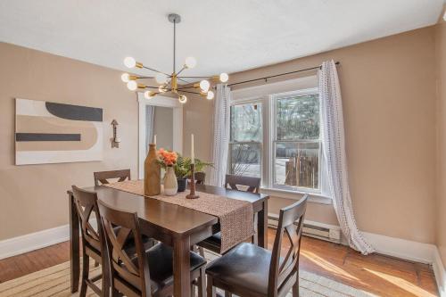 a dining room with a table and chairs and a chandelier at Modern 6BR Near Syracuse U, Destiny & Zoo Sleeps 18 in Syracuse