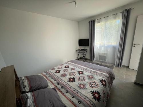 une chambre avec un lit avec une couverture dessus dans l'établissement Alicante, à Causses-et-Veyran