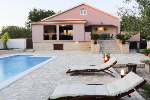 a backyard with a swimming pool and a house at Villa Marija ZadarVillas in Poličnik