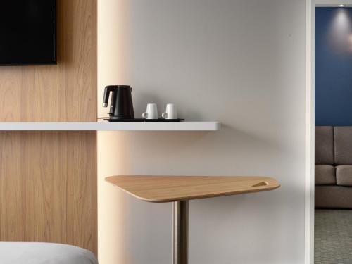 a room with a table with a coffee maker on a shelf at Holiday Inn Express Hasselt by IHG in Hasselt