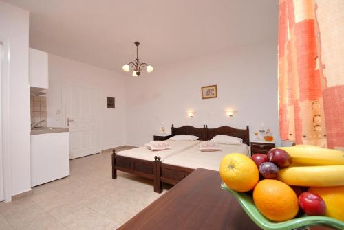 a room with a bed and a bowl of fruit on a table at Sea Melody Studios in Plaka