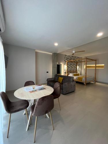 a living room with a table and chairs and a bed at La LIPA in Almáchar