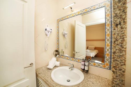 a bathroom with a sink and a mirror at Solar das Bouças by Quantique in Amares