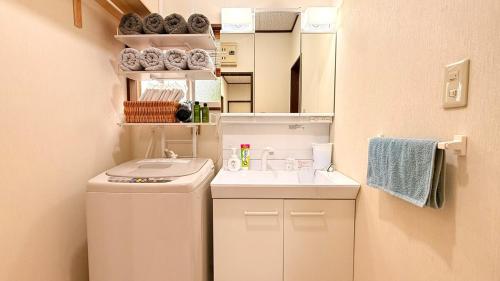 a small bathroom with a washing machine and a sink at 月の城Moon City最大10名様まで絶景とBBQを満喫 in Bizen